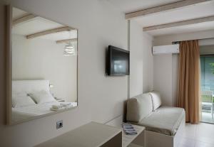 a mirror in a room with a bed and a couch at Altamar Hotel in Pefki