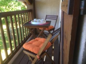 - une table et une chaise en bois sur une terrasse couverte dans l'établissement Stemicar dans les Landes, à Lesperon