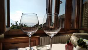 two wine glasses sitting on a table in front of a window at Casa Bella Vista in Baveno +41 photos