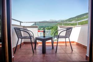 two chairs and a table on a balcony at Hotel Odissey Jaz in Budva