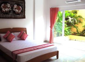 a bedroom with a bed and a window at Jomtien Hostel in Jomtien Beach