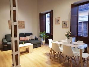 sala de estar con mesa y sofá en Apartamentos Granada Deluxe 3000, en Granada