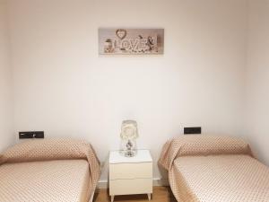 dos camas sentadas una al lado de la otra en una habitación en Apartamentos Granada Deluxe 3000, en Granada