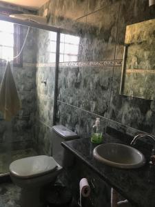 a bathroom with a toilet and a sink at Hostel Ares do Mundo in Miguel Pereira