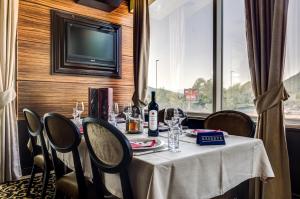 a table with a bottle of wine on it in a room with a window at Hotel Odissey Jaz in Budva