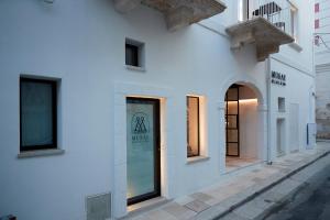 a white building with a window on a street at Musae Relais & SPA in Polignano a Mare