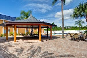 un pavillon avec une table, des chaises et un palmier dans l'établissement Quality Inn & Suites Heritage Park, à Kissimmee