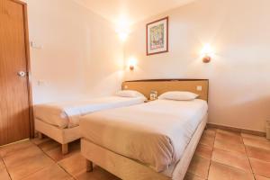 a hotel room with two beds and a chair at Campanile Setubal in Setúbal +42 photos