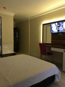 a bedroom with a bed and a flat screen tv at ANKARA ATLANTİK OTEL in Etimesut