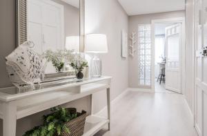 einen weißen Flur mit einem Konsole-Tisch und einer Lampe in der Unterkunft Anamar in Pamplona + 31 Fotos