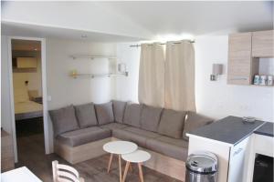 a living room with a couch and a table at Mobile Home Neuf AZ 27 in Fréjus