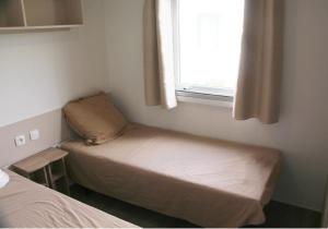 a small room with two beds and a window at Mobile Home Neuf AZ 27 in Fréjus +12 photos