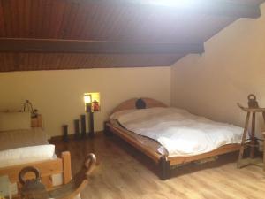 a bedroom with two beds and a wooden floor at La petite maison en pierres in Gras
