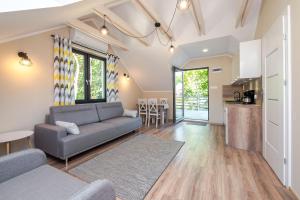 a living room with a couch and a kitchen at Apartamenty Parkowa 13 in Darłówko