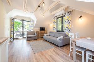 a living room with a couch and a table at Apartamenty Parkowa 13 in Darłówko +12 photos