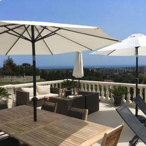 a table with two umbrellas on a balcony at Villa La Riviera in Mandelieu-la-Napoule