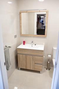 een badkamer met een wastafel en een spiegel bij Ca Roxa in Pravia