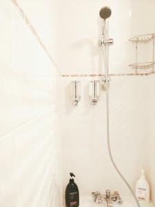 La salle de bains blanche est pourvue d'une douche et d'un lavabo. dans l'établissement Studio Royal by Beds4Wanderlust - Place du marché avec parking privé, à Fontainebleau 28 autres photos