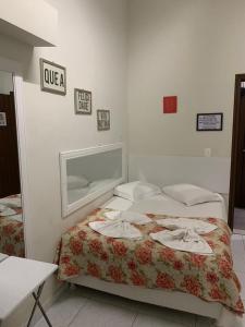 1 dormitorio con 1 cama y un cartel en la pared en Pousada Flor Dália, en Natal