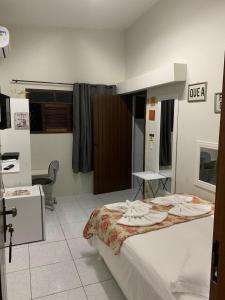 Habitación hospitalaria con cama y escritorio en Pousada Flor Dália, en Natal