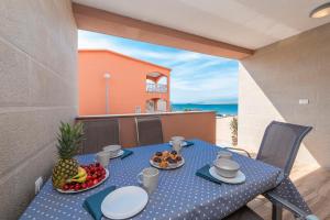 a blue table with food on a balcony with the ocean at LUXURY APARTMENTS - LA VIR 1 & 2 in Vir