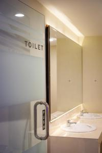 a bathroom with two sinks and a large mirror at The Capsule Malioboro in Yogyakarta