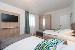 a hotel room with two beds and a flat screen tv at LUXURY APARTMENTS - LA VIR 1 & 2 in Vir