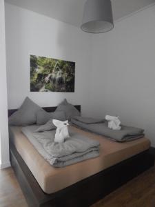 a bedroom with two beds with towels and a painting at FREE Apartment - Am Kurpark in Bad Urach