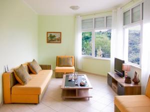 a living room with a couch and a table at Villa Rossa in Utjeha