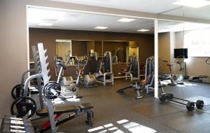 a gym with several tread machines and a mirror at Grand Hotel Ter Duin in Burgh Haamstede
