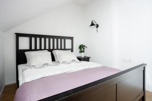 a bedroom with a large bed with a black headboard at Baron Arthouse Apartment in Vilnius