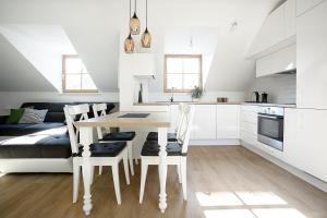 a kitchen with white cabinets and a table and chairs at Baron Arthouse Apartment in Vilnius