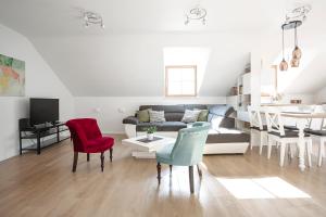 a living room with a couch and chairs and a table at Baron's Arthouse Apartment in Vilnius