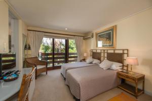a bedroom with a bed and a desk and a television at Auberge de Courtrai in Paarl +75 photos