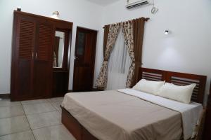 een slaapkamer met een bed met witte lakens en een raam bij Alleppey - The Beach Home in Alleppey