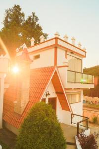 une maison avec un toit orange et un balcon dans l'établissement Pousada Palos Verdes, à Monte Verde