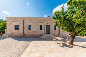 a building with a table and chairs in front of it at Villa Vittoria in Cisternino