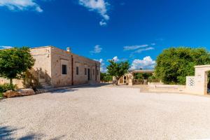 an old building with a gravel driveway in front of it at Villa Vittoria in Cisternino