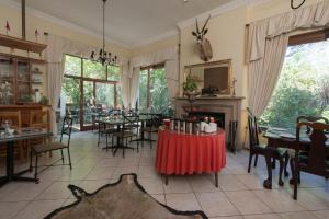 a dining room with tables and chairs and a fireplace at Auberge de Courtrai in Paarl