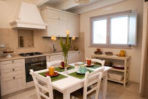 a kitchen with a table with a vase of flowers at Villa Vittoria in Cisternino