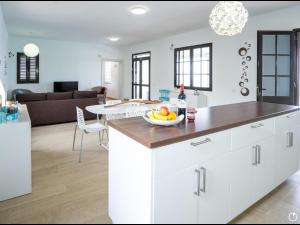 a white kitchen with a bowl of fruit on a counter at Casa Ocean View in Mácher