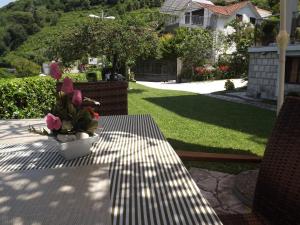 a table with a vase of pink flowers on it at Apartments MaXhit in Tivat