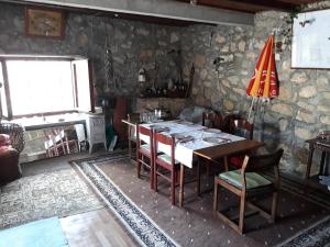 a dining room with a table with chairs and a red umbrella at Konoba in Cetinje