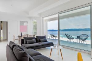 un soggiorno con un divano e una grande finestra di Villa V - private pool, special location & surroundings a Mimice