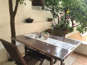 a wooden table and chairs in a room with trees at Apartments Jani in Hvar