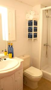 La salle de bains blanche est pourvue de toilettes et d'un lavabo. dans l'établissement Apartamento turístico en Sevilla, à Séville