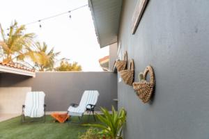 two chairs and wicker baskets on the side of a house at La Casita Torres in Oranjestad