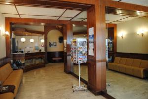 eine Lobby mit Sofas und einem Spiegel in einem Gebäude in der Unterkunft Hôtel Royal in Lourdes
