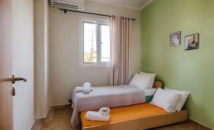 a small bedroom with a bed with a window at Gennadi Villa Del Mar in Gennadi
