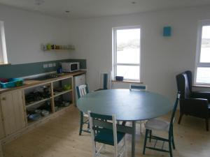 eine Küche mit einem Tisch und Stühlen im Zimmer in der Unterkunft Otter Bunkhouse in Cairisiadar